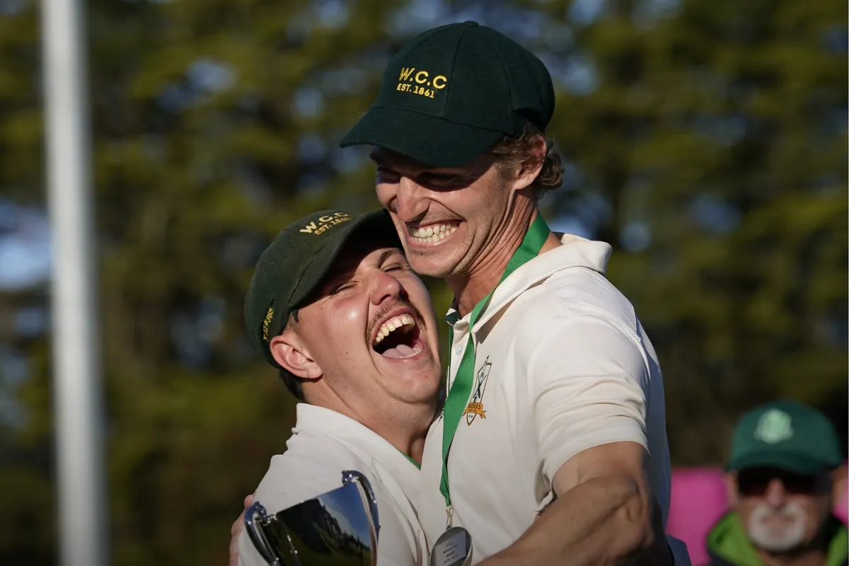 Two Woodend First XI players embrace with the McIntyre Cup after the 2025/26 grand final