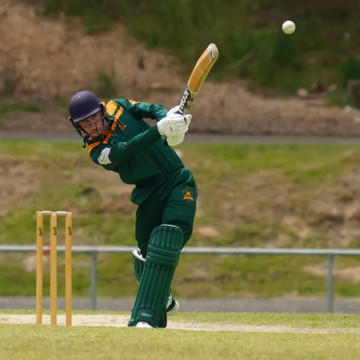 A Woodend junior batter in green